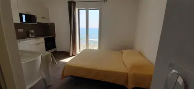 a small room with a kitchen with a view of the ocean at Résidence Pascal Paoli Fior di Mare in Moriani Plage