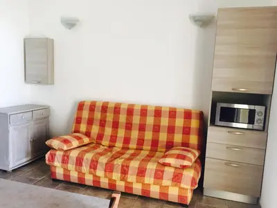 a living room with a couch and a microwave at Résidence Pascal Paoli Fior di Mare in Moriani Plage
