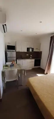 a room with a kitchen and a table and a bed at Résidence Pascal Paoli Fior di Mare in Moriani Plage