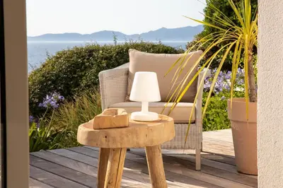 a chair and a table with a lamp on a deck at A Casa Nostra in Coti-Chiavari