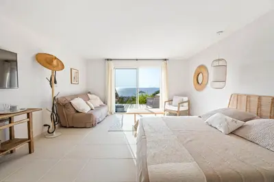 a white bedroom with a bed and a couch at A Casa Nostra in Coti-Chiavari