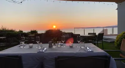 a table with wine glasses and the sunset in the background at A Casa Nostra in Coti-Chiavari