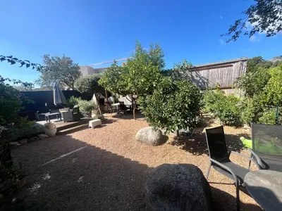 a yard with a garden with chairs and trees at FIORINO in Sainte-Lucie de Porto-Vecchio