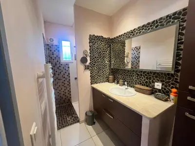 a bathroom with a sink and a mirror at FIORINO in Sainte-Lucie de Porto-Vecchio