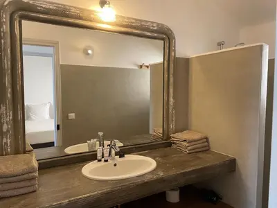 a bathroom with a sink and a large mirror at Domaine Pietra di Sole in Porto-Vecchio