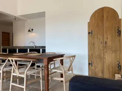 a kitchen with a wooden table and chairs at Domaine Pietra di Sole in Porto-Vecchio