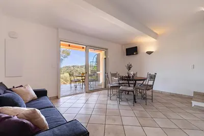 a living room with a couch and a table and chairs at Domaine Pietra di Sole in Porto-Vecchio