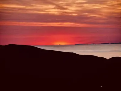 a sunset over the ocean with the sun setting in the distance at Résidence Casa Di Roc in Urtaca