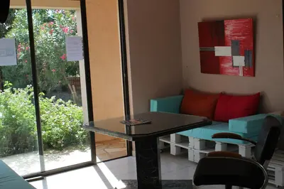 a table and chairs in a room with a window at Chambres d'hôtes Le Clos des Oliviers in Sorbo-Ocagnano