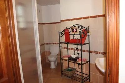 a bathroom with a toilet and a towel rack at Chambres d'hôtes Le Clos des Oliviers in Sorbo-Ocagnano