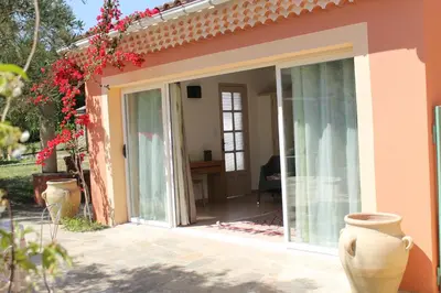 an open sliding glass door of a house at Chambres d'hôtes Le Clos des Oliviers in Sorbo-Ocagnano