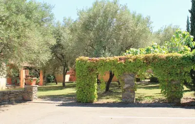 an arch covered in ivy in a park at Chambres d'hôtes Le Clos des Oliviers in Sorbo-Ocagnano