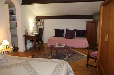 a living room with a bed and a table at Domaine Le Clos des Oliviers in Sorbo-Ocagnano