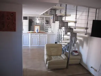 a living room with a chair and a spiral staircase at MARE BELLU AGOSTA PLAGE in Albitreccia
