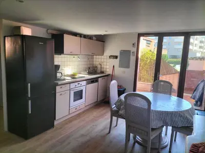 a small kitchen with a table and a table and chairs at MARE BELLU AGOSTA PLAGE in Albitreccia