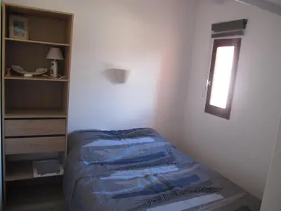 a small bedroom with a bed and a window at MARE BELLU AGOSTA PLAGE in Albitreccia