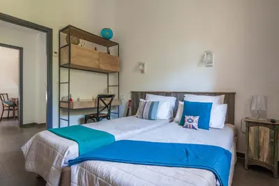 a bedroom with a large bed with blue and white pillows at la villa piana Ardiadoro in Bocca del Oro