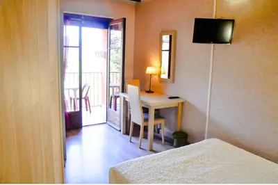 a bedroom with a desk and a table with a television at Résidence Stella Marina in Serriera