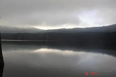 a view of a lake with the sun reflecting on the water at U San Larenzu in Aullène