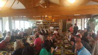 a group of people sitting at tables in a restaurant at U San Larenzu in Aullène