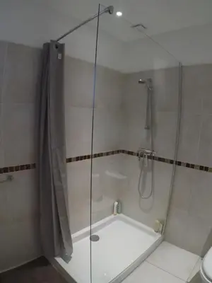 a shower with a glass door in a bathroom at A Dugana in Lecci
