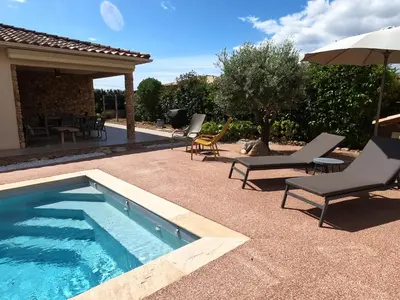 a swimming pool with lounge chairs and an umbrella at A Dugana in Lecci