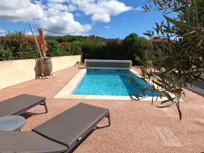 a swimming pool with two chaise lounges next to at A Dugana in Lecci