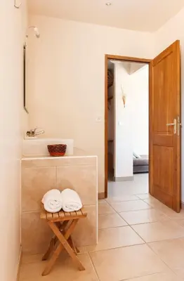 a bathroom with a sink and two towels on a table at Le Ruone in Calcatoggio