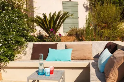 a couch with pillows and a table on a patio at Le Ruone in Calcatoggio