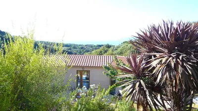 a small house in the middle of a garden at Le Ruone in Calcatoggio