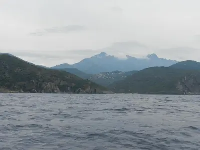 a large body of water with mountains in the background at Les Asphodèles in Partinello