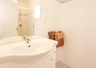 a white bathroom with a sink and a shower at Résidence Dicieppo in Ajaccio