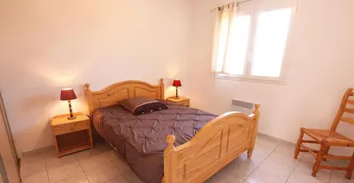 a bedroom with a bed and two lamps and a window at Résidence Dicieppo in Ajaccio