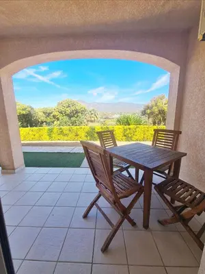 a wooden table and chairs on a patio with a view at Résidence Dicieppo in Ajaccio