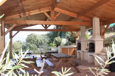 a wooden pavilion with a picnic table and an oven at Résidence Dicieppo in Ajaccio