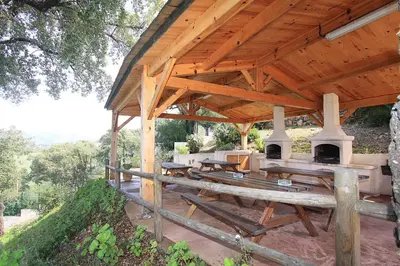 a wooden pavilion with picnic tables and a grill at Résidence Dicieppo in Ajaccio