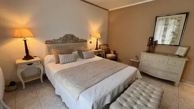 a bedroom with a large bed and a dresser and lamp at Chez Virginie in Porto-Vecchio