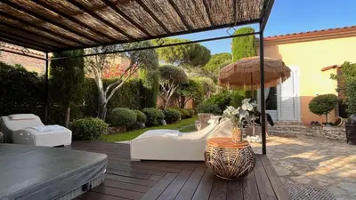 a patio with a couch and an umbrella at Chez Virginie in Porto-Vecchio