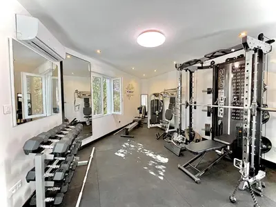 a gym with several treadmills and machines in a room at Residence Canella in Sari Solenzara