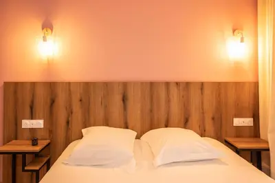 a bedroom with a bed with two pillows on it at Auberge les Oliviers in Lucciana