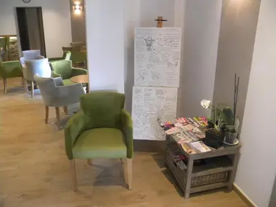 a room with a green chair and a table at Auberge les Oliviers in Lucciana
