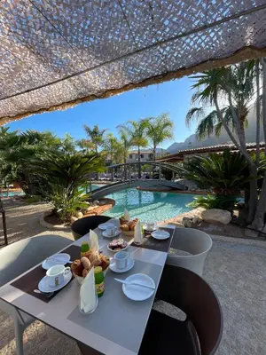 a table with food on it next to a swimming pool at Résidence & SPA Marina d'Arone in Piana