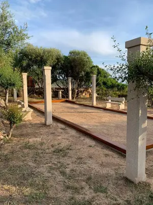 a walkway in a park with trees in the background at Résidence & SPA Marina d'Arone in Piana
