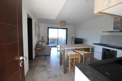 a kitchen and living room with a table and chairs at Domaine du Frasso in Grosseto-Prugna