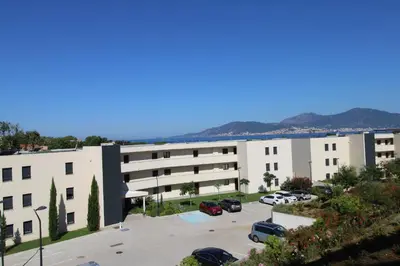 a large white building with a parking lot at Domaine du Frasso in Grosseto-Prugna