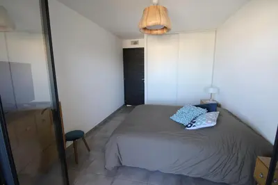 a small bedroom with a bed and a chair at Domaine du Frasso in Grosseto-Prugna