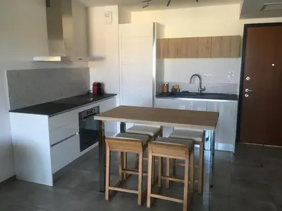 a kitchen with a wooden table and some stools at Domaine du Frasso in Grosseto-Prugna