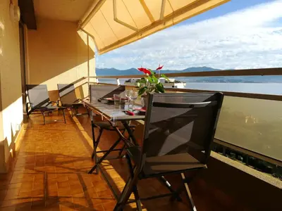 a balcony with a table and chairs and a television at Le Parc Impérial in Ajaccio