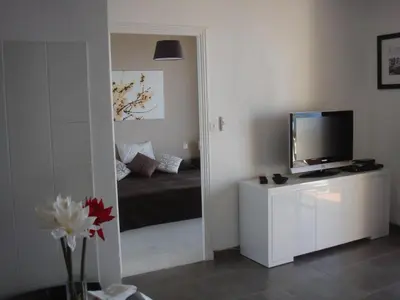 a bedroom with a bed and a television in a mirror at Le Parc Impérial in Ajaccio