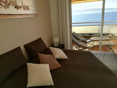 a bedroom with a bed with a view of the ocean at Le Parc Impérial in Ajaccio